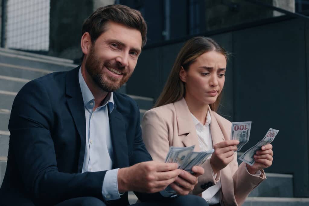 Two business man and woman in city counting money cash happy smile rich male and sad frustrated female businessman with businesswoman gender inequality financial unequal discrimination sexism at work. High quality 4k footage